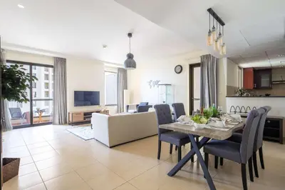 a dining room and living room with a table and chairs at Frank Porter - Murjan 1 in Dubai