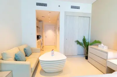 a living room with a couch and a table at Seven Palm Residences Palm Jumeirah by Happy Season in Dubai
