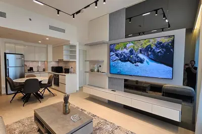 a living room with a large flat screen tv on a wall at Downtown Dubai views 2 tower 1 in Dubai