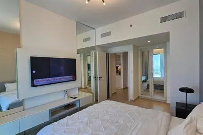 a bedroom with a bed and a flat screen tv at Downtown Dubai views 2 tower 1 in Dubai