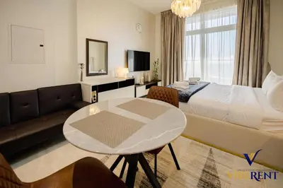 a hotel room with a bed and a table at Stylish and Cozy Studio Apartment in Dubai