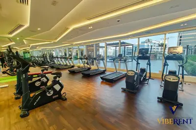 a gym with a bunch of treadmills and elliptical machines at Stylish and Cozy Studio Apartment in Dubai