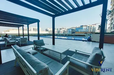 a patio with couches and a table on a roof at Stylish and Cozy Studio Apartment in Dubai
