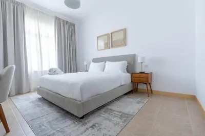 a bedroom with a large white bed and a window at Elegant 1BR beach access with Ocean Views, Palm in Dubai