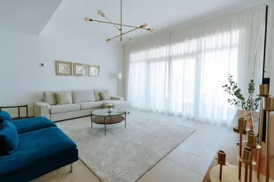 a living room with a blue couch and a table at Elegant 1BR beach access with Ocean Views, Palm in Dubai