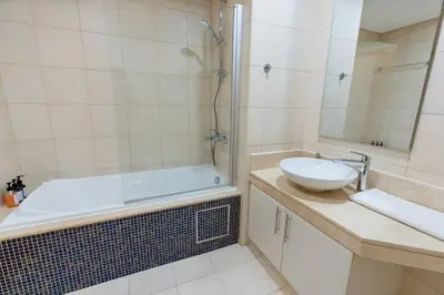 a bathroom with a tub and a sink and a shower at Elegant 1BR beach access with Ocean Views, Palm in Dubai