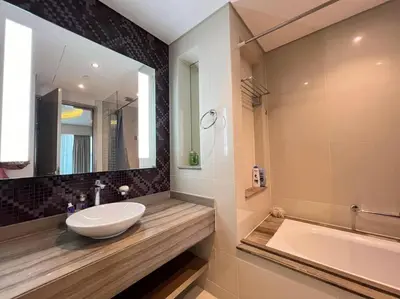 a bathroom with a sink and a tub and a mirror at Luxurious & Modern 1BR DAMAC Paramount Business Bay in Dubai