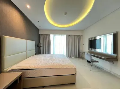 a bedroom with a bed and a desk and a television at Luxurious & Modern 1BR DAMAC Paramount Business Bay in Dubai