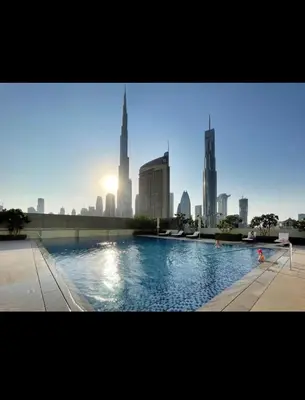 a swimming pool with a city skyline in the background at Downtown views-access to Dubai Mall! in Dubai