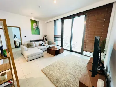 a living room with a couch and a tv at Downtown views-access to Dubai Mall! in Dubai
