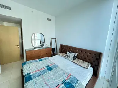 a bedroom with a bed and a dresser and a mirror at Downtown views-access to Dubai Mall! in Dubai