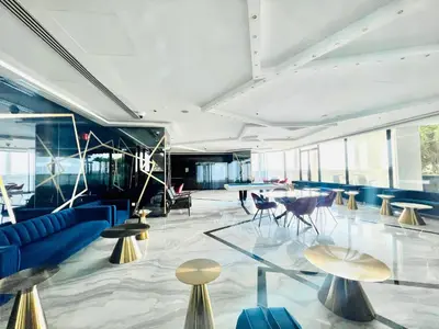 a lobby with blue furniture and tables and windows at Modern Studio in Business Bay in Dubai