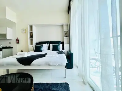 a bedroom with a large bed and a large window at Modern Studio in Business Bay in Dubai