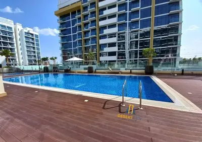 a swimming pool in front of a large building at Fully Furnished One Bed in Meydan, Hosted by Desert City Stays in Dubai