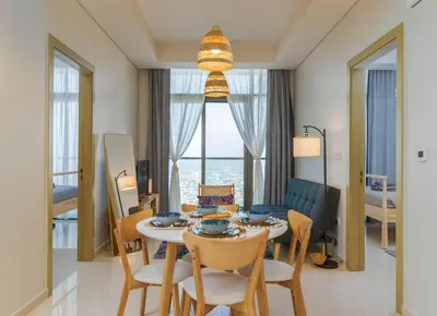 a living room with a table and chairs and a room at Samani vacation Homes 5701 in Dubai