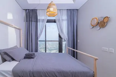 a bedroom with a bed and a large window at Samani vacation Homes 5701 in Dubai