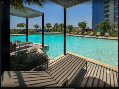 a large swimming pool with chairs and a building at Samani vacation Homes 5701 in Dubai