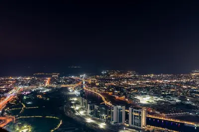 a view of a city at night with lights at Samani vacation Homes 5701 in Dubai