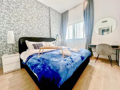 a bedroom with a bed and a table and a mirror at Luxury 2 Bedroom in the Nook 1 next to Metro Energy in Dubai