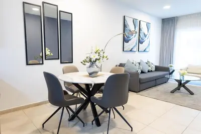 a living room with a table and chairs and a couch at Elite Residences Tower Dubai Marina by Happy Season in Dubai