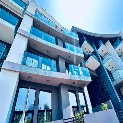 a large building with blue windows on it at Modern 1-Bedroom La Perla Apartment JVC with Infinity Pool & Kids’ Zone in Dubai