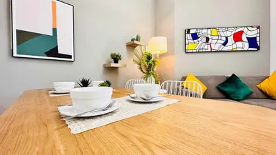 a dining room table with two cups and plates on it at Modern 1-Bedroom La Perla Apartment JVC with Infinity Pool & Kids’ Zone in Dubai