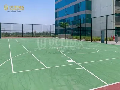 a tennis court in front of a building at Elegant 2BR Burj Khalifa view-Downtown Views II in Dubai