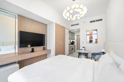 a bedroom with a large white bed and a flat screen tv at Studio Azizi Riviera 28 Community View in Dubai