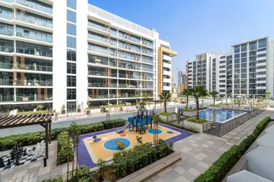 an apartment complex with a playground and buildings at Studio Azizi Riviera 28 Community View in Dubai