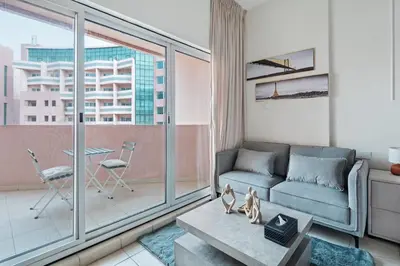 a living room with a couch and a large window at Urban Designer Apt - Family Friendly in Dubai