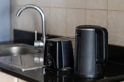a toaster sitting on a kitchen counter next to a sink at Urban Designer Apt - Family Friendly in Dubai
