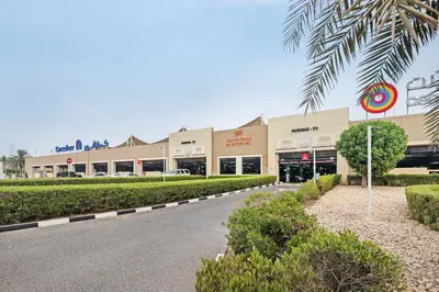 a shopping mall with a palm tree in front of it at Urban Designer Apt - Family Friendly in Dubai