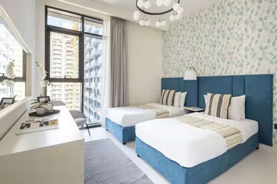 a hotel room with two beds and a desk at Frank Porter - Marina Vista tower 2 in Dubai