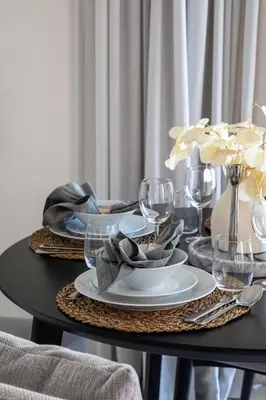 a black table with plates and wine glasses on it at Frank Porter - Marina Vista tower 2 in Dubai