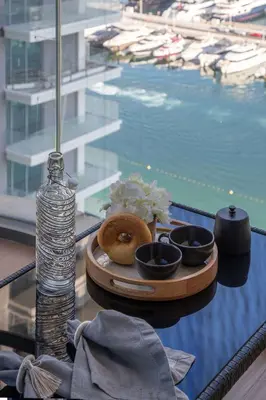 a table with a tray of donuts on a table near a pool at Frank Porter - Marina Vista tower 2 in Dubai
