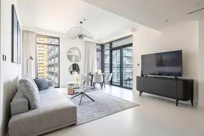 a living room with a couch and a tv and a table at Frank Porter - Marina Vista tower 2 in Dubai