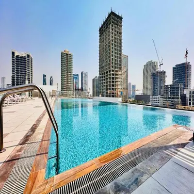a large swimming pool on top of a city skyline at Premium 1-Bedroom Perla Apartment in JVC | Infinity Pool & Kids’ Play Area in Abu Dhabi