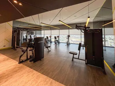 a gym with treadmills and machines in a room at Frank Porter - Aykon City Tower C in Dubai