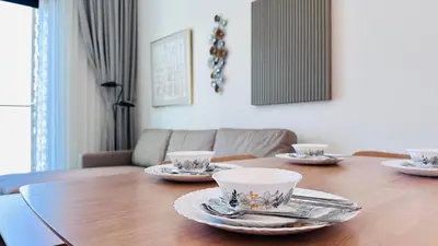 a wooden table with plates and cups on top of it at Standard 1bedroom Apartment Binghatti Emerald JVC in Dubai