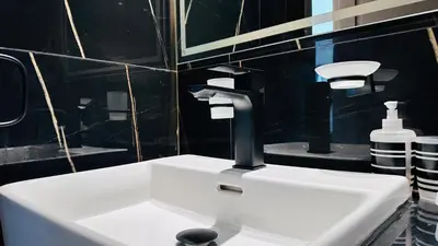 a white sink in a bathroom with a black wall at Standard 1bedroom Apartment Binghatti Emerald JVC in Dubai