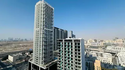 a tall white building in a city with buildings at Standard 1bedroom Apartment Binghatti Emerald JVC in Dubai