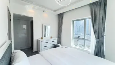 a bedroom with a white bed and a large window at Dubai Marina- Cozy 2BHK Apartment in Dubai