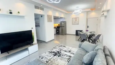 a living room with a couch and a tv and a table at Dubai Marina- Cozy 2BHK Apartment in Dubai