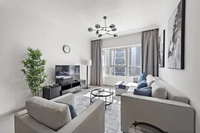 a living room with two couches and a tv at Spacious 1-Bedroom Apartment in JLT in Dubai