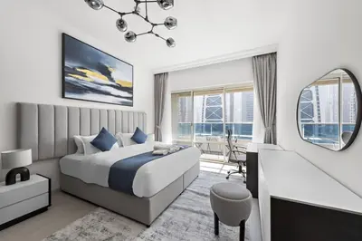 a bedroom with a bed and a desk and a mirror at Spacious 1-Bedroom Apartment in JLT in Dubai