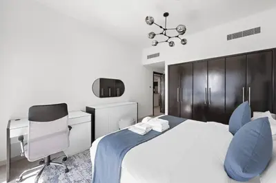 a bedroom with a bed and a desk and a chair at Spacious 1-Bedroom Apartment in JLT in Dubai