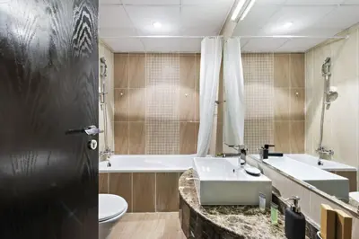 a bathroom with a sink and a tub and a toilet at Spacious 1-Bedroom Apartment in JLT in Dubai