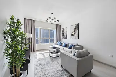 a living room with a couch and a table at Spacious 1-Bedroom Apartment in JLT in Dubai