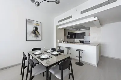 a dining room with a table and chairs and a kitchen at Spacious 1-Bedroom Apartment in JLT in Dubai