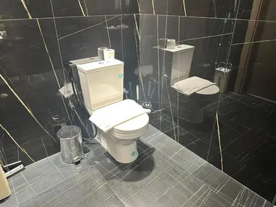 a bathroom with a toilet and a trash can at Stylish 1br Jvc Spacious Layout Pool View in Dubai